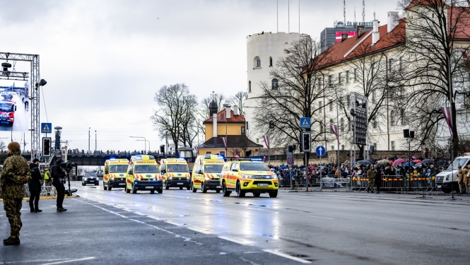 NMPD operatīvie auto brauc pa ielu, fonā prezidenta pils